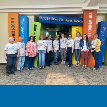 12 staff members standing in front of entrance to children's room